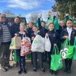 Donations for the needy with students and Father Victor Adams